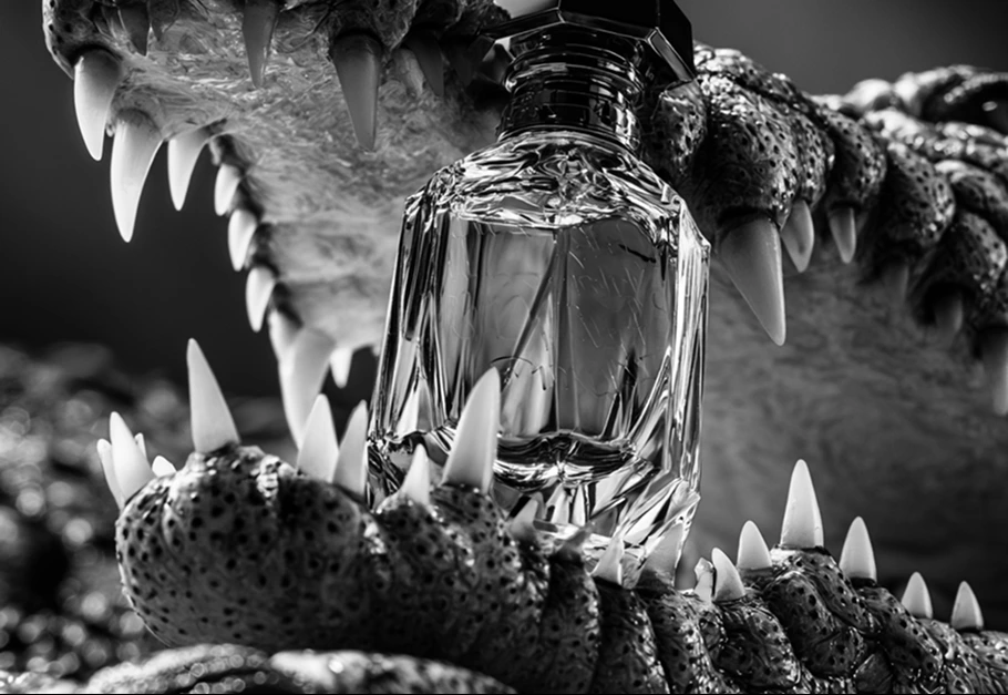 Glass perfume bottle framed by crocodile textures